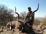 Ethical trophy hunter with mature Kudu in Namibia, showcasing responsible wildlife management.